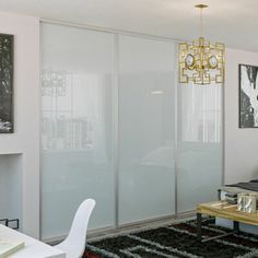 a bedroom with white walls and black rugs on the floor next to a bed