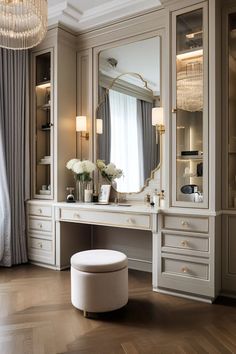 an elegant dressing room with white furniture and chandelier