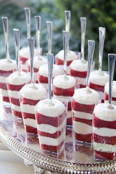 red and white desserts are arranged on a silver platter