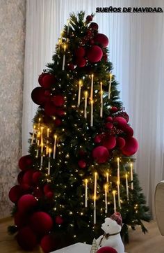 a christmas tree decorated with red balls and candles