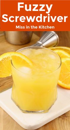 a glass filled with orange juice on top of a cutting board