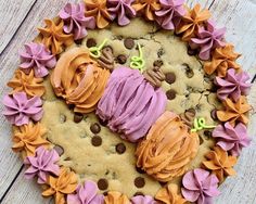 a cookie with purple frosting and orange icing in the shape of a heart