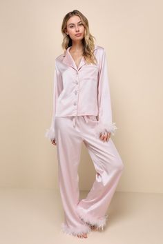 With the Lulus Dreamiest Delight Light Pink Satin Feather Two-Piece Pajama Set, you'll look so good that you'll never want to go to bed! This sleek pajama set has a sexy woven satin construction that shapes a collared neckline and long sleeves with fluffy, feather-trimmed cuffs. The relaxed, button-up bodice features dazzling, rhinestone-encrusted buttons and a front patch pocket. The matching bottoms boast a high elasticized waist with a cinching drawstring tie, that tops straight pant legs that fall to feather-adorned, ankle-grazing hems. Fit: This garment fits true to size. Length: Ankle length. Size medium Inseam: 30.00 Front Rise: 12.25 Bust: Great for any cup size. Waist: Fitted - elastic waist allows stretch. Hip: Loosely Fitted. Undergarments: May be worn with any standard bra. Fab Light Pink Christmas Outfit, Feather Trim Pajamas, Princess Diaries Pajama Party, Cutesy Pajamas, Women’s Pajamas, Pink Pajamas Aesthetic, Pajama Party Grown Up, Princess Pjs, Christmas Pajamas Aesthetic