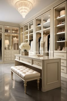 a walk in closet with white furniture and chandelier