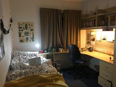 a room with a bed, desk and computer