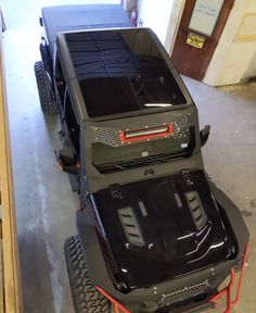 an electric vehicle parked in a garage with its hood up and the back end off