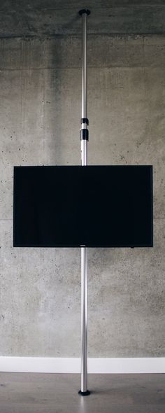 an empty room with concrete walls and a metal pole holding a large black sign in the center