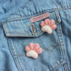 two pink and white dog paws are on the back of a jean jacket