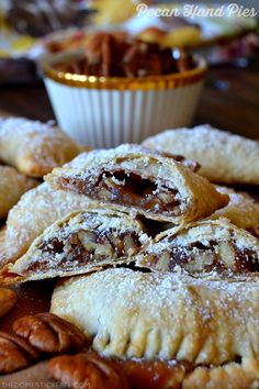 several pastries on a wooden table with nuts and other food items in the background