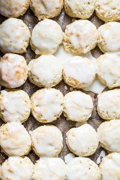 baked biscuits covered in white icing on a baking sheet