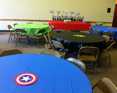 a room filled with tables and chairs covered in blue tablecloths next to each other