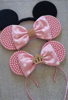 three minnie mouse ears with pink and white polka dots on them, one has a gold bow