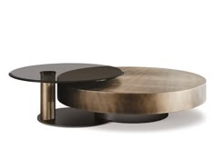 two round tables with metal bases on each side, one is black and the other is gold