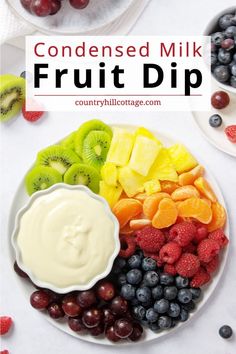 a white plate topped with fruit dip next to grapes, kiwis and strawberries