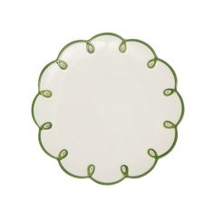 a white plate with green trim around the edge and an oval design on the rim