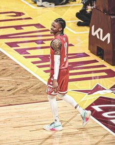 a basketball player walking on the court with his foot in the air while wearing red and white