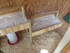 two wooden benches sitting next to each other on top of a carpeted floor in front of a wall