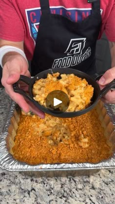 a person in an apron holding a pan filled with macaroni and cheese casserole