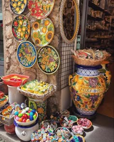 there are many colorful plates and bowls on display