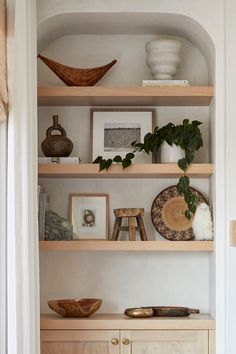 the shelves in this room are filled with vases, pictures and other decorative items