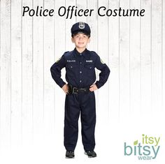 a young boy dressed as a police officer standing in front of a white wooden wall