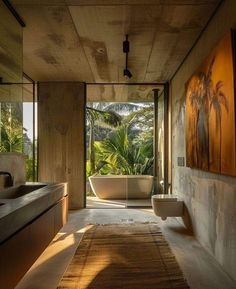 a bathroom with a bathtub, sink and large mirror on the wall next to it