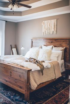 a bedroom with a bed, rug and ceiling fan in the middle of the room