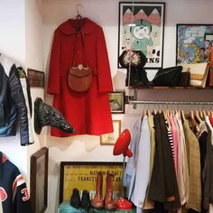 a closet with clothes and shoes hanging on the wall next to a shelf filled with other items