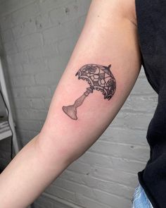 a person with a tattoo on their arm holding an object in the shape of a fish