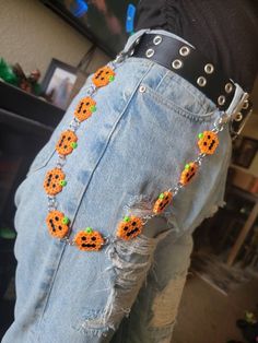 a person wearing an orange and black beaded pumpkin necklace on their waist with holes in the middle