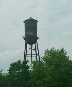 an old water tower in the middle of trees