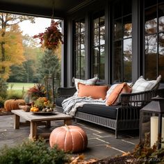 a porch with pumpkins and other fall decorations on the outside patio, as well as an outdoor seating area