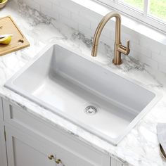 a white sink sitting on top of a counter next to a cutting board and knife