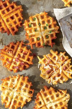 four waffles on a baking sheet with some sprinkled cheese and peas