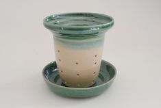 a green and white cup sitting on top of a saucer