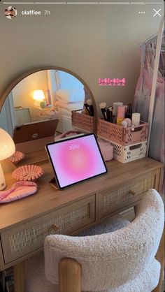 a laptop computer sitting on top of a wooden desk next to a lamp and mirror