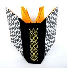 an origami book with black and yellow designs