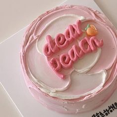 a pink cake with white frosting that says dear peace