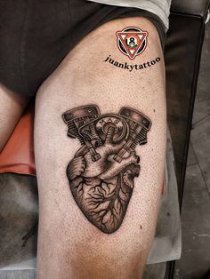 a tattoo on the leg of a man with a heart and two wrenches in it