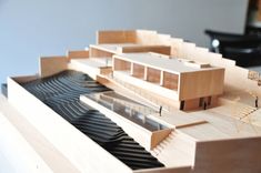 a wooden model of a house on top of a piano