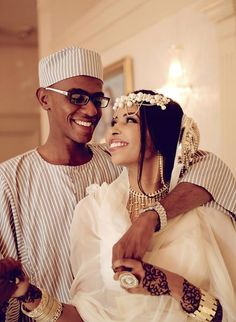 a man and woman dressed in traditional african garb smile as they pose for the camera