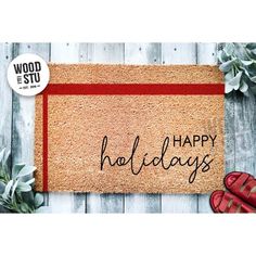 a door mat with the words happy holidays written on it and red shoes next to it