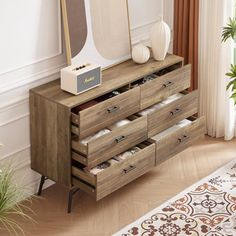 a wooden dresser with drawers and a mirror on it's top shelf next to a potted plant