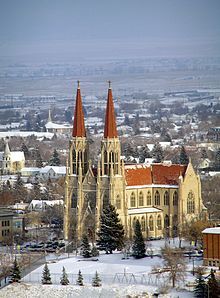 an aerial view of a church with red steeples and snow on the ground in front of it