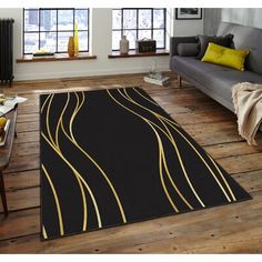 a black and gold rug in a living room with wood flooring on the floor