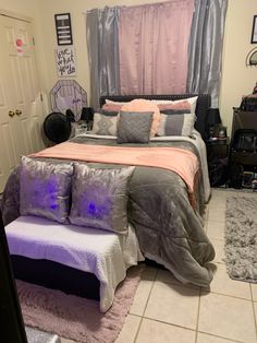 a bed room with a neatly made bed and purple comforter on the top of it