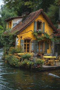 a yellow house sitting on the side of a river