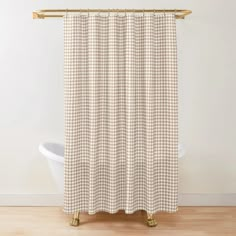 a white and brown checkered shower curtain hanging on a bathroom wall next to a bathtub