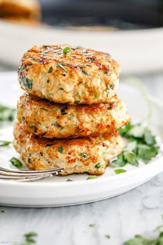 three crab cakes stacked on top of each other with a fork in front of them