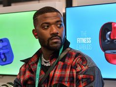 a man standing in front of two televisions with earbuds on their ears